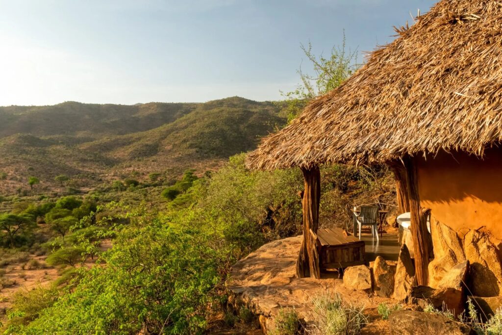 Thatched banda perched above the valley at Tassia Lodge