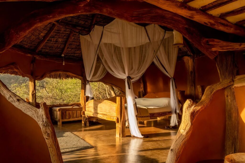 Hand-carved canopy bed in a Tassia Lodge cottage
