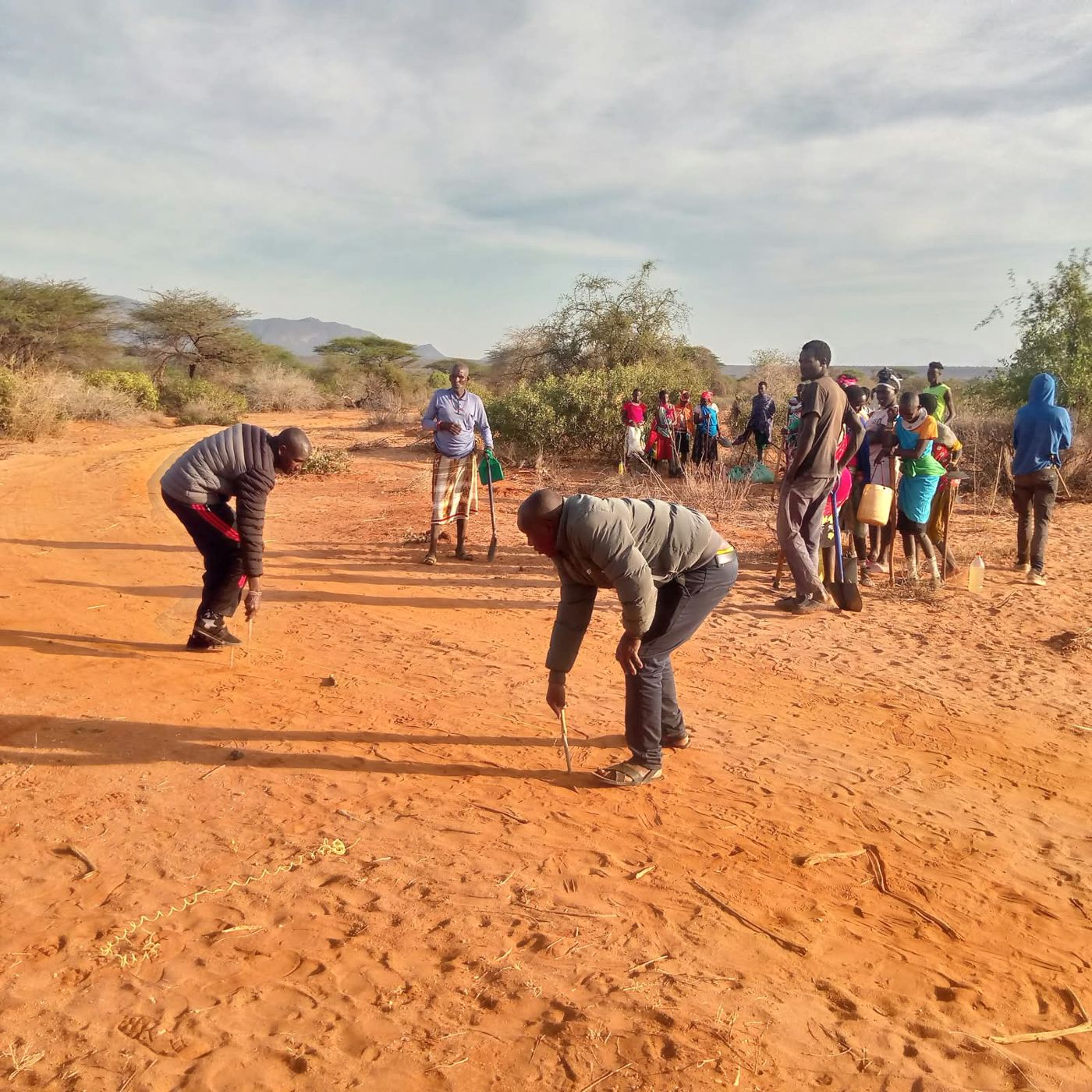 Conservancy staff measuring and marking the layout for semi-circular bunds at Tenge Block